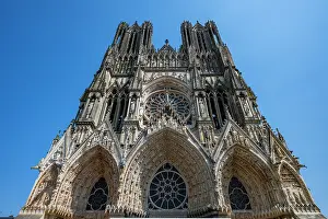 Windows Prints: Notre Dame Cathedral stands tall under a clear blue sky in a landmark of architectural beauty and history in Reims