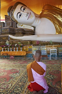 Pegu Prints: Nun in front of reclining Buddha statue, Shwethalyaung, Bago (Pegu), Myanmar (Burma), Asia