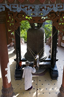 Giant Prints: Nun ringing a giant bell, Long Son Pagoda, Vietnam, Indochina, Southeast Asia, Asia