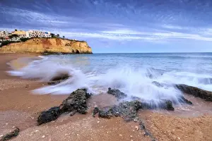 Ocean waves crashing on rocks and beach surrounding Carvoeiro village at sunset, Lagoa Municipality