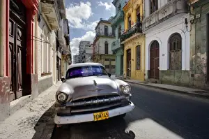 Street Scenes Prints: Old American Plymouth car parked on deserted street of old buildings, Havana Centro
