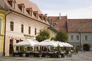 Old buildings and street cafe in historic city centre of Hermannstadt, Piata Mare