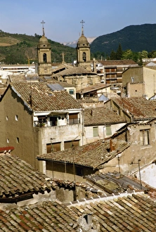 Euskadi Prints: Old buildings with tiled roofs and a church behind
