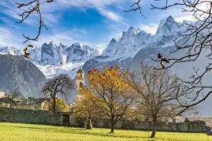 Soglio Prints: Old church lit by autumn colors with snowcapped Piz Badile and Cengalo in the background