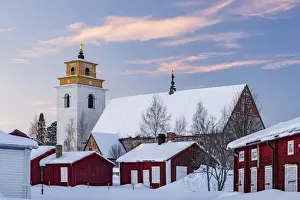 Old church and picturesque buildings covered with snow at sunset in Gammelstad old town, UNESCO World Heritage Site, Lulea, Sweden, Scandinavia, Europe