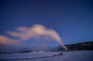 Old Faithful geyser under a starry sky, Yellowstone National Park