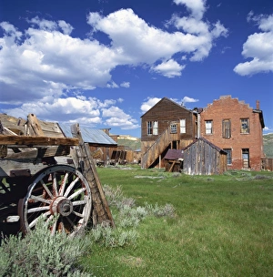 Old farm wagon and derelict wooden and brick houses