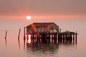 Venetian Prints: Old fishermens shack at sunset in Venetian lagoon off the coast of Pellestrina, Venice