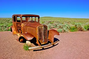 Vintage Car Prints: The old rusting steel shell of a Model-T mounted on concrete pillars along the old