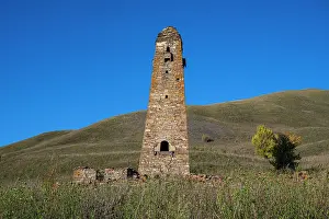 Terrain Prints: Old watchtower stands alone on a mountain in Chechnya against a clear blue sky