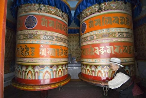 Spinning Prints: Old woman pushing prayer wheels, Jingang Si, Kangding, Sichuan, China, Asia