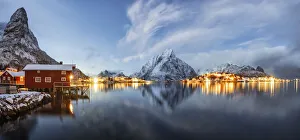 Nordland Gallery: Olstind mount and traditional red fishermens cabins mirrored in the cold sea at dusk