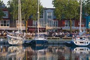 Charente Maritime Prints: Open-air restaurants overlooking yachts moored in the ancient harbour at La Rochelle