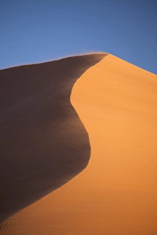 Sesriem Prints: The orange sand and snaking ridge of Elim Dune against blue sky