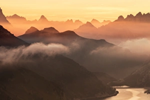 Orange sky at dawn and mist on peaks of Dolomites and Fedaia Pass, Cima Belvedere Orange sky at dawn and mist on peaks of Dolomites and Fedaia Pass, Cima Belvedere