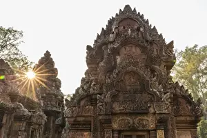 10th Century Prints: Ornate carvings in red sandstone at sunset in Banteay Srei Temple in Angkor