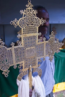 Symbols Prints: Orthodox monk standing behind a Christian cross, Axum, Ethiopia, Africa