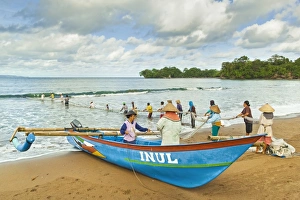 Outrigger fishing boat and people pulling net in by hand to shore near Batu Karas, Pangandaran, West Java, Java, Indonesia, Southeast Asia, Asia Outrigger fishing boat and people pulling net in by hand to shore near Batu Karas, Pangandaran, West Java, Java, Indonesia, Southeast Asia, Asia