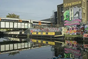Graffiti Prints: Overground train drives past canal by artists studios and warehouses in Hackney Wick