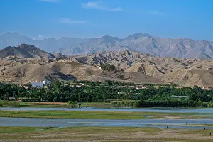 Kabul Prints: Overlook of the Kabul river showing distant mountains and green fields near Jalalabad in bright daylight with clear sky