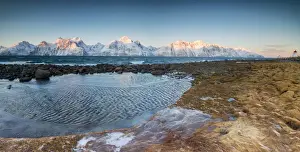 Lyngen Alps Prints: Panorama of frozen sea and snowy peaks at dawn surrounded by rocks covered with ice