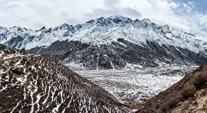 Snow Covered Prints: Panorama overlooking the vast high altitude mountains of Langtang Valley Trek with snow plains near Kyanjin Gompa