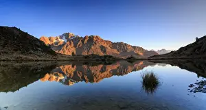 Mountain Peak Prints: Panorama of the rocky peaks of Mount Disgrazia reflected in Lake Zana at dawn