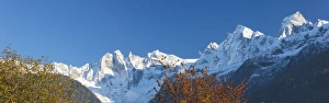 Jagged Prints: Panorama of the snowy peaks framed by colorful trees, Soglio, Bregaglia Valley, Canton