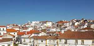 Alentejo Prints: Panoramic cityscape view over pan tile rooftops and whitewashed buildings in the city centre of Evora