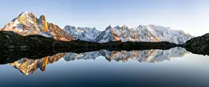 Panoramic of Mont Blanc Massif covered with snow reflected in Lacs de Cheserys at sunset