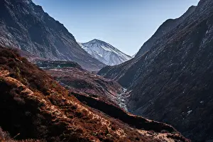 Footpath Prints: Panoramic trail view toward snow-covered Tserko Ri peak with steep ridges and valley terrain in Langtang Valley