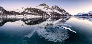 Engadine Prints: Panoramic view of the icy surface of Lake Sils at sunrise, Engadine Valley, Graubunden
