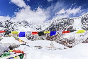 Routes Prints: Panoramic View of Langtang Lirung and Langtang Valley Framed by Colorful Prayer Flags on Snowy Kyanjin Ri Summit