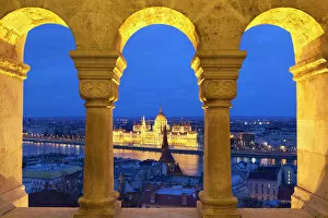 Images Dated 17th December 2011: Parliament (Orszaghaz) through arches of Fishermens Bastion (Halaszbastya) at dusk