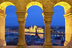 Budapest Prints: Parliament (Orszaghaz) through arches of Fishermens Bastion (Halaszbastya) at dusk