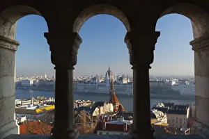 Parliament (Orszaghaz) and River Danube through arches of Fishermens Bastion (Halaszbastya), UNESCO World Heritage Site, Buda, Budapest, Hungary, Europe