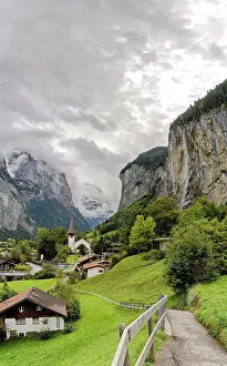 Pure Prints: Path among green meadows of the alpine village of Lauterbrunnen with Trummelbach Falls in the background