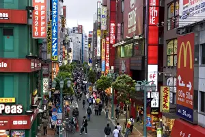 Shinjuku Prints: A pedestrian street lined with shops and signboards attracts a crowd in Shinjuku