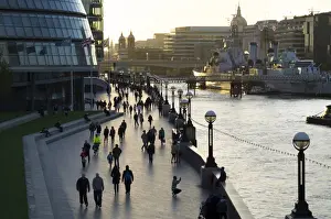 Hms Belfast Prints: Pedestrians silhouetted on More Place riverfront with City Hall and HMS Belfast behind