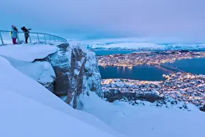 Sightseer Prints: People admire the city of Tromso at dusk from the mountain top reached by the Fjellheisen cable car