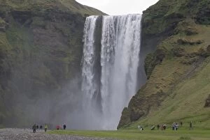 People admiring the big waterfall of Skogarfoss, Iceland, Polar Regions