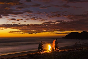 Nicoya Peninsula Prints: People with driftwood fire at sunset on Playa Guiones beach