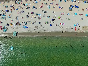Bright Prints: People enjoy a sunny day on Legenese cove beach in Carnac