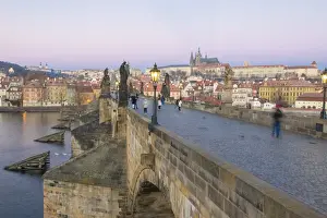 People on the historical Charles Bridge on Vltava River at dawn, UNESCO World Heritage Site