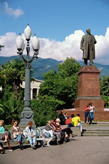 Ukraine Prints: People sitting on benches near a statue of Lenin in Yalta