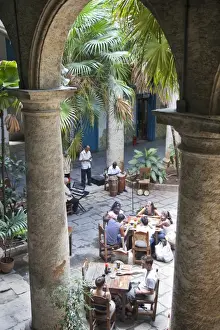 Tables Prints: People sitting at tables and musicians playing in courtyard of colonial building built in 1780
