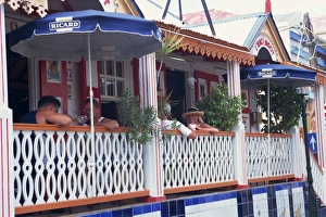 Leeward Island Prints: People sitting at tables on the terrace in a restaurant