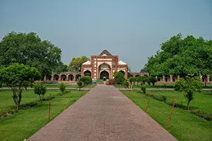 Walkway Prints: People stroll along the pathway towards the main entrance of Akbari Sarai