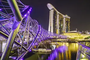 People strolling on the Helix Bridge towards the Marina Bay Sands and ArtScience Museum at night