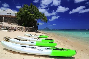 Enjoyment Prints: People walk on the beach while kayaks rest on the sand at a tropical location with blue sky and water in Mauritius